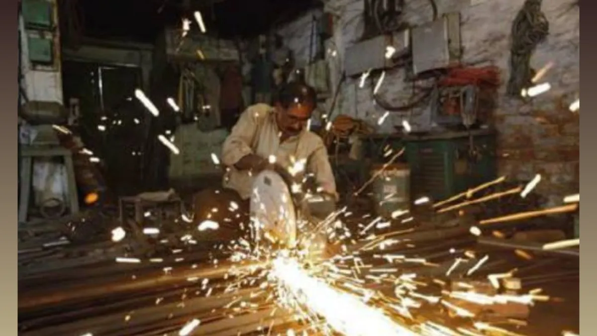 A worker using a power-driven machine to cut metal, which is a key activity within the manufacturing sector